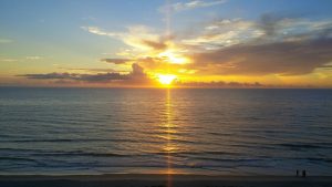 Consultation appointment photo of rising sun on water bringing warmth and light